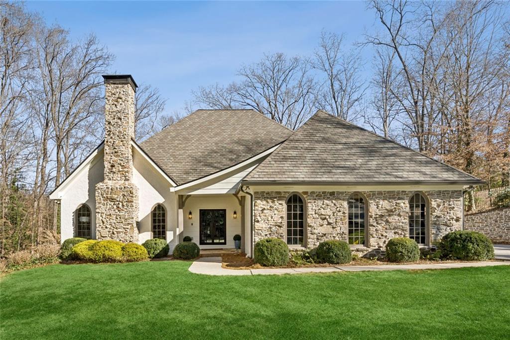 4575 Jett Road Atlanta, GA 30327 - Photo 1 of 42 a front view of a house with a garden and trees