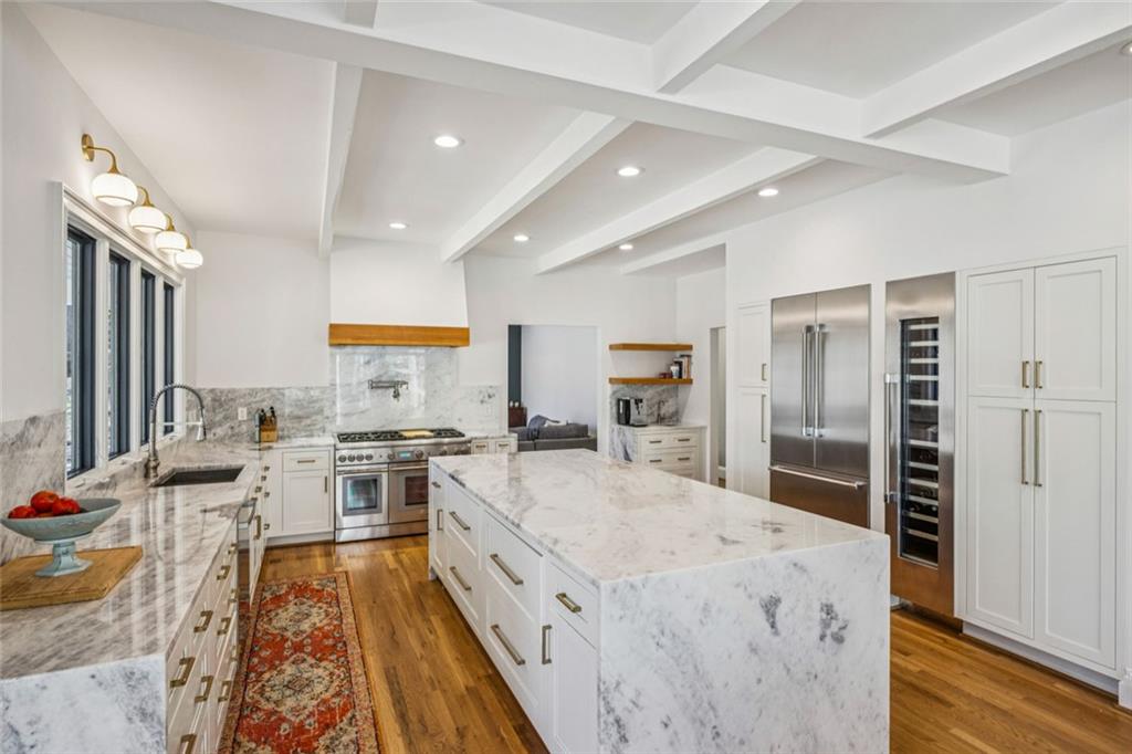 4575 Jett Road Atlanta, GA 30327 - Photo 11 of 42 a large kitchen with stainless steel appliances a stove a sink dishwasher and a refrigerator with wooden floor