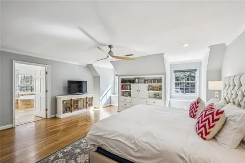 a spacious bedroom with a bed and a flat screen tv