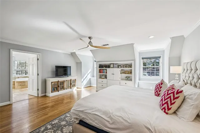 a spacious bedroom with a bed and a flat screen tv