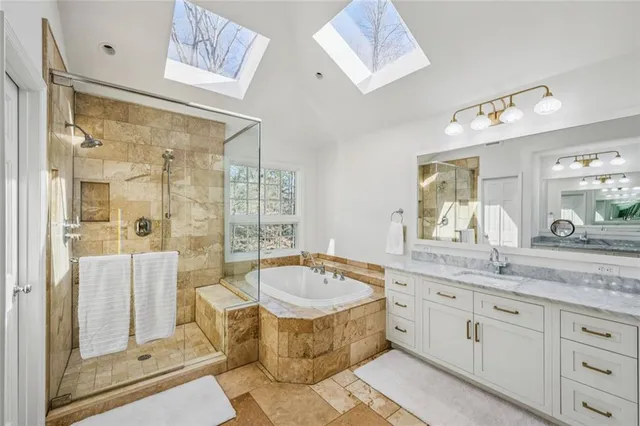 a spacious bathroom with a tub sink shower and mirror