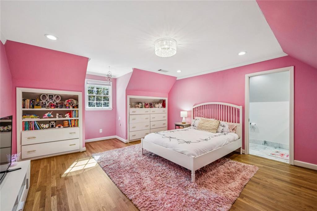 4575 Jett Road Atlanta, GA 30327 - Photo 25 of 42 a spacious bedroom with a bed and a dresser with wooden floor