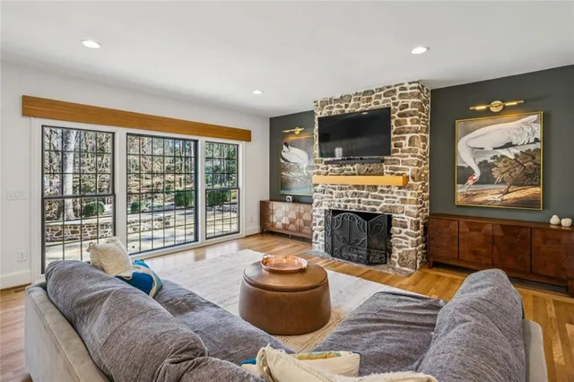 a living room with furniture a flat screen tv and a fireplace