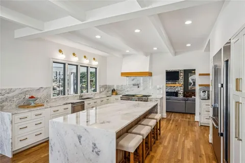 a large kitchen with kitchen island a large counter space a sink appliances and cabinets