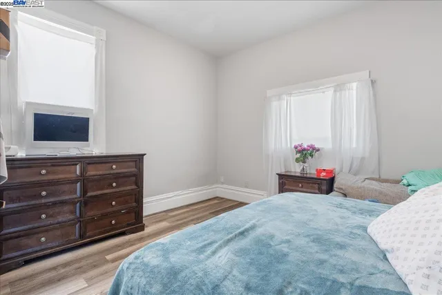 a bedroom with a bed and two windows