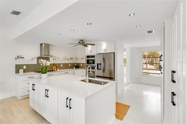 a kitchen with stainless steel appliances a refrigerator sink and microwave