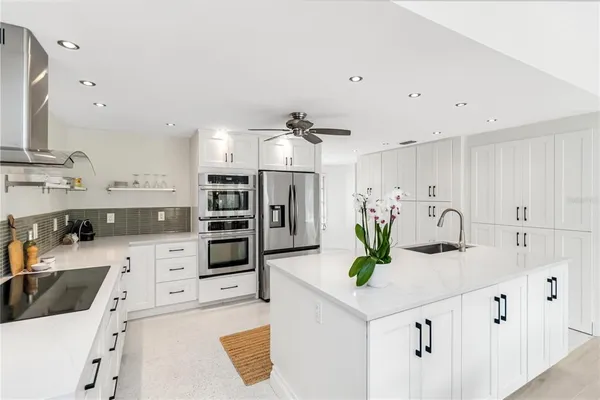 a kitchen with kitchen island white cabinets and refrigerator