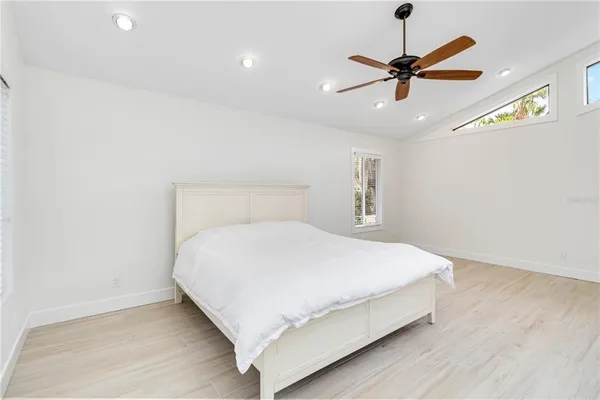 a bedroom with a bed and a ceiling fan