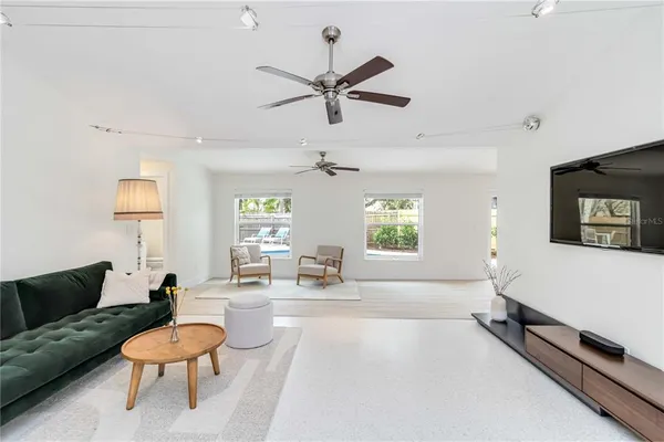 a living room with patio furniture and a wooden floor