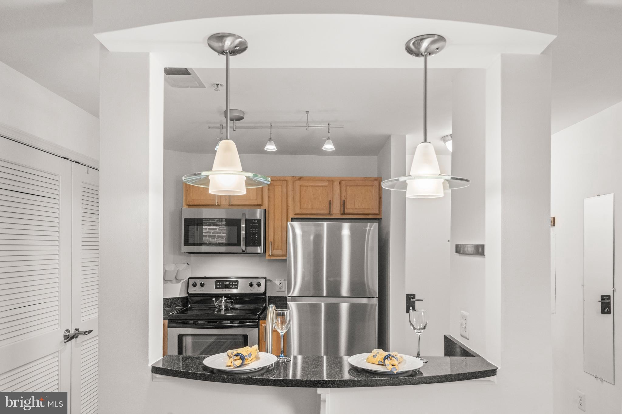 1106 Columbia Road Northwest, Unit 304 Washington, DC 20009 - Photo 9 of 24 a kitchen with stainless steel appliances granite countertop a refrigerator and a sink
