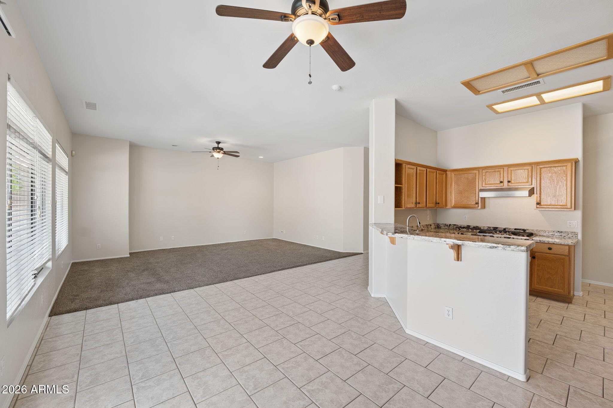 4418 East Jaeger Road Phoenix, AZ 85050 - Photo 6 of 42 a open kitchen with white cabinets a sink dishwasher and a stove with wooden floor