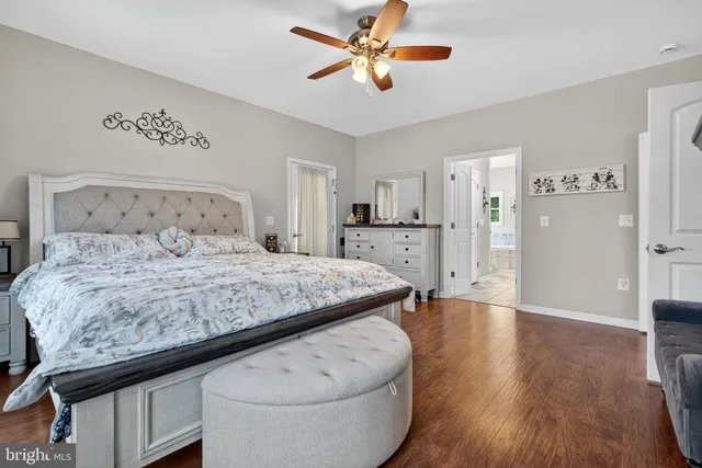 a living room with furniture and a bookshelf with wooden floor