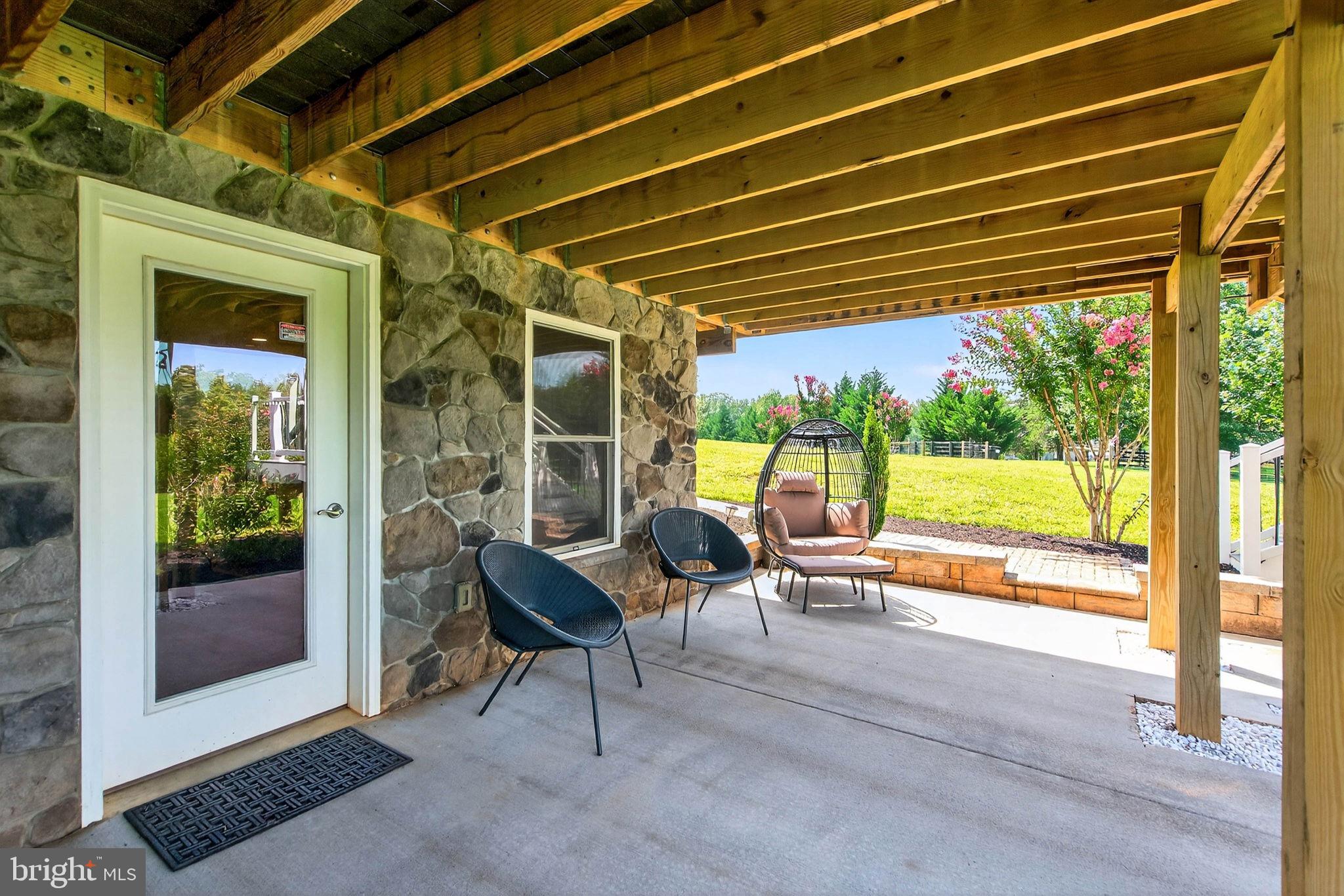 14451 Jenkins Ridge Road Culpeper, VA 22701 - Photo 60 of 78 a view of porch with a table and chairs under an umbrella