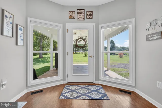 a kitchen with stainless steel appliances a dining table chairs stove refrigerator and sink