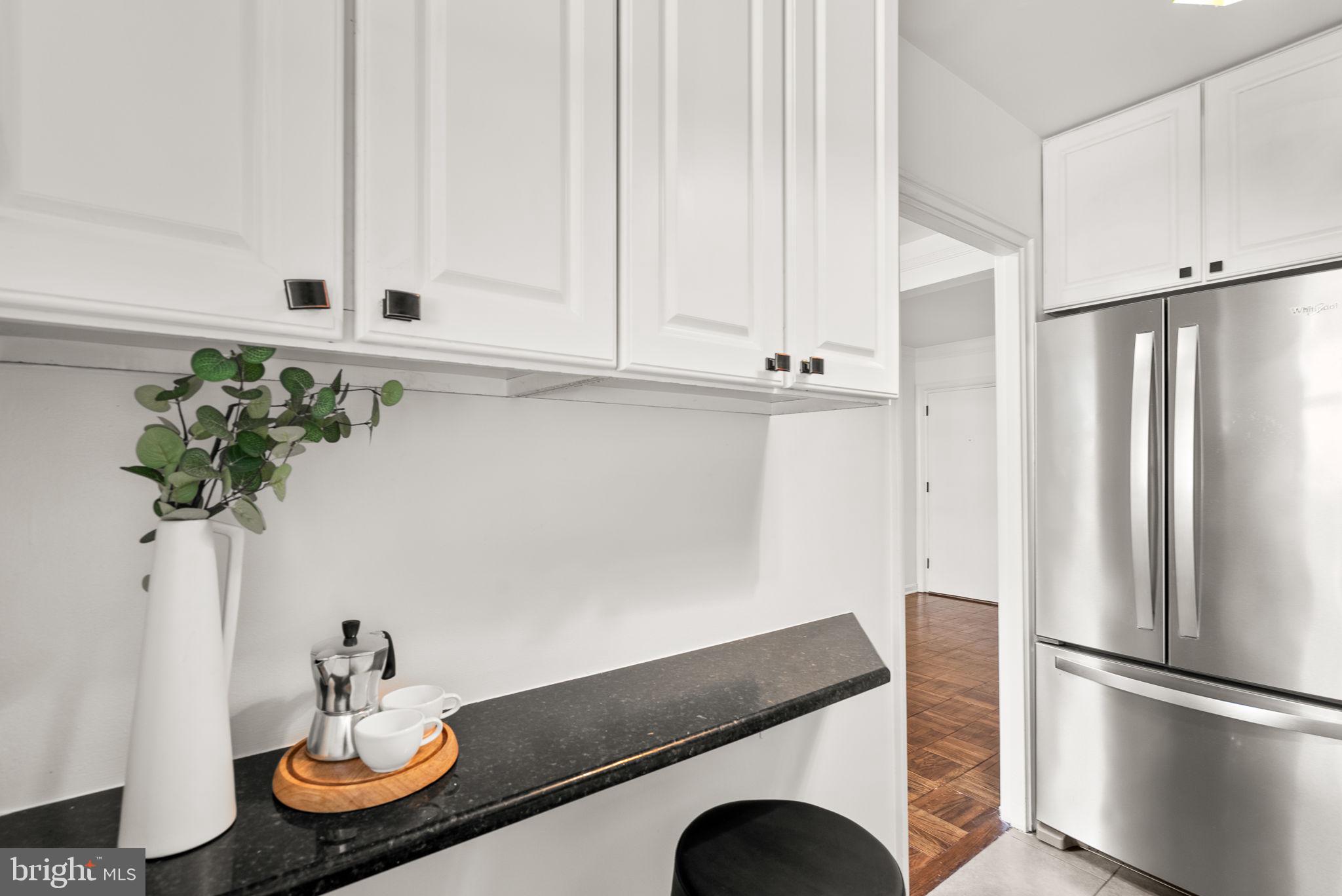 4820 Chevy Chase Drive, Unit 101 Chevy Chase, MD 20815 - Photo 12 of 30 a kitchen with stainless steel appliances granite countertop a refrigerator and a sink