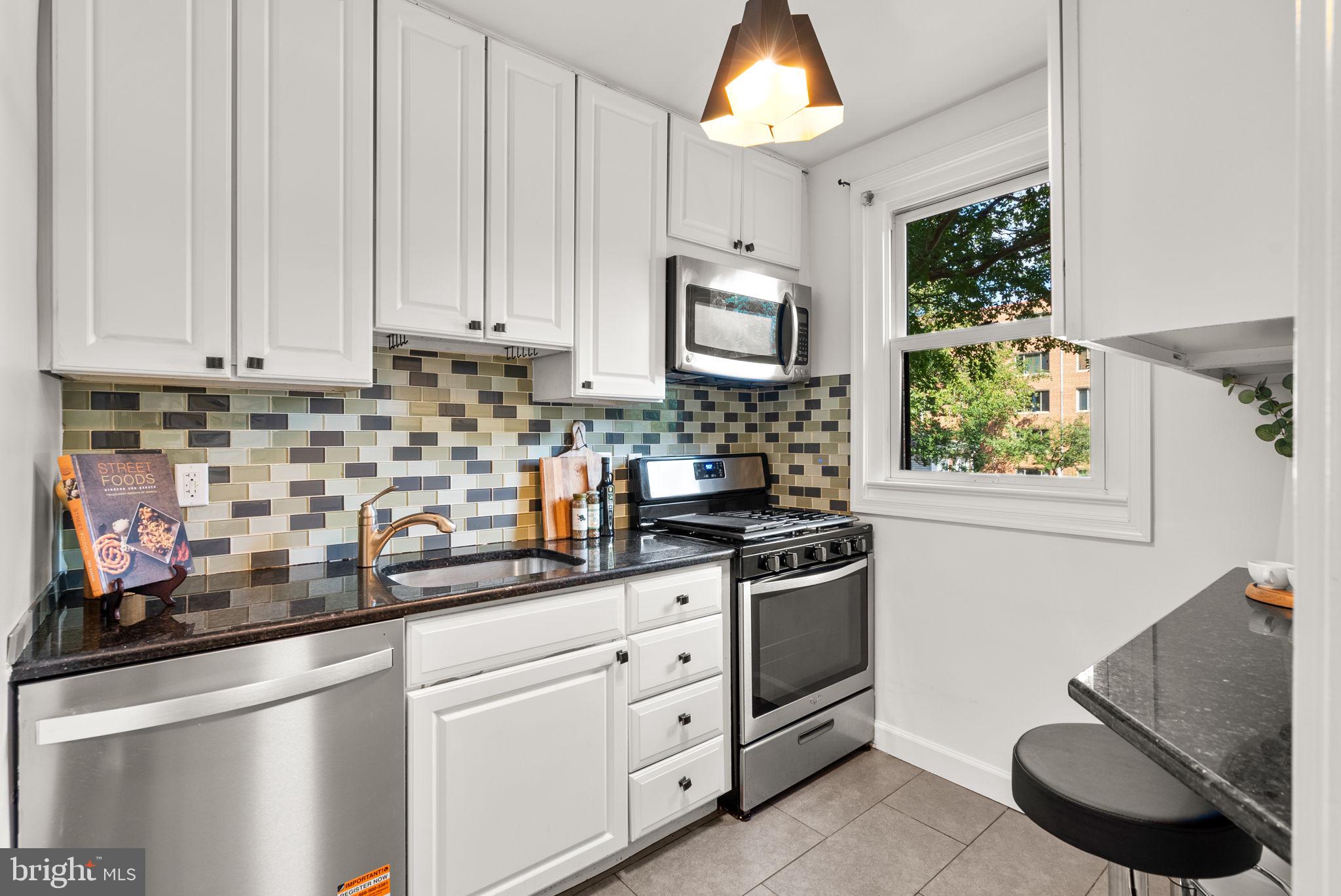 4820 Chevy Chase Drive, Unit 101 Chevy Chase, MD 20815 - Photo 14 of 30 a kitchen with stainless steel appliances granite countertop a stove a sink and a white cabinets