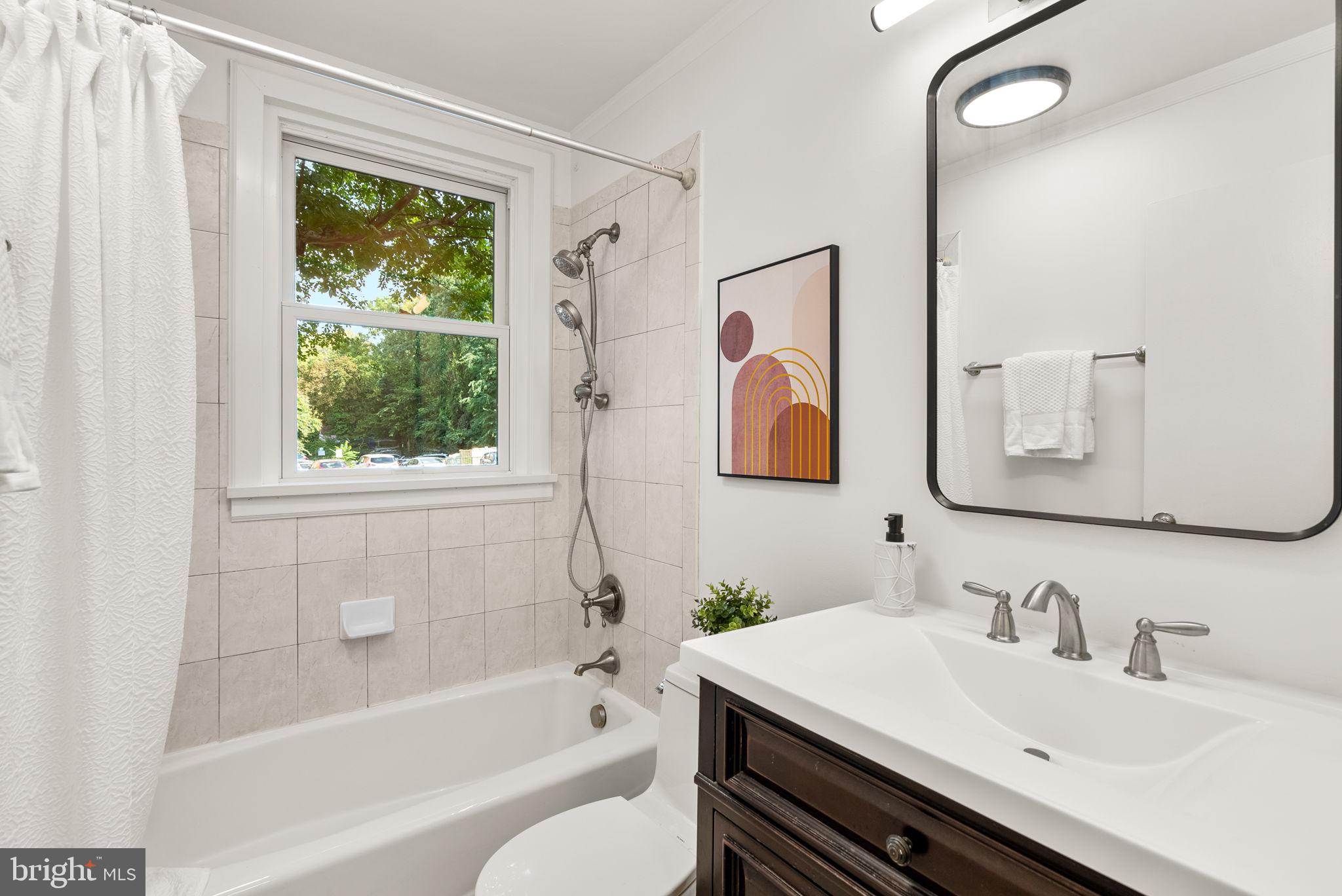 4820 Chevy Chase Drive, Unit 101 Chevy Chase, MD 20815 - Photo 20 of 30 a bathroom with a sink toilet and shower