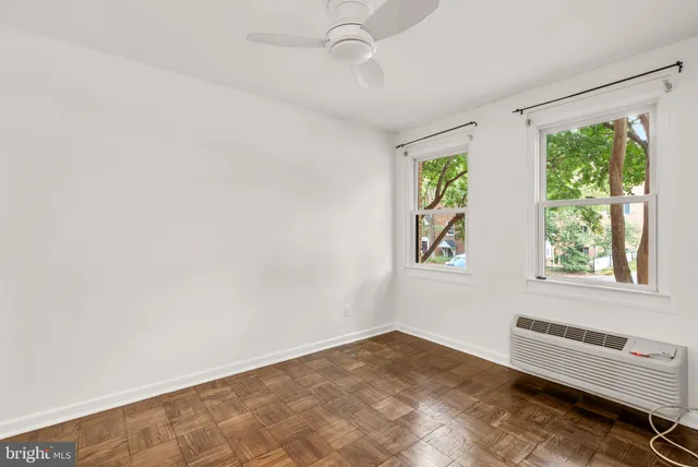 a view of a bedroom with a window and a ceiling fan