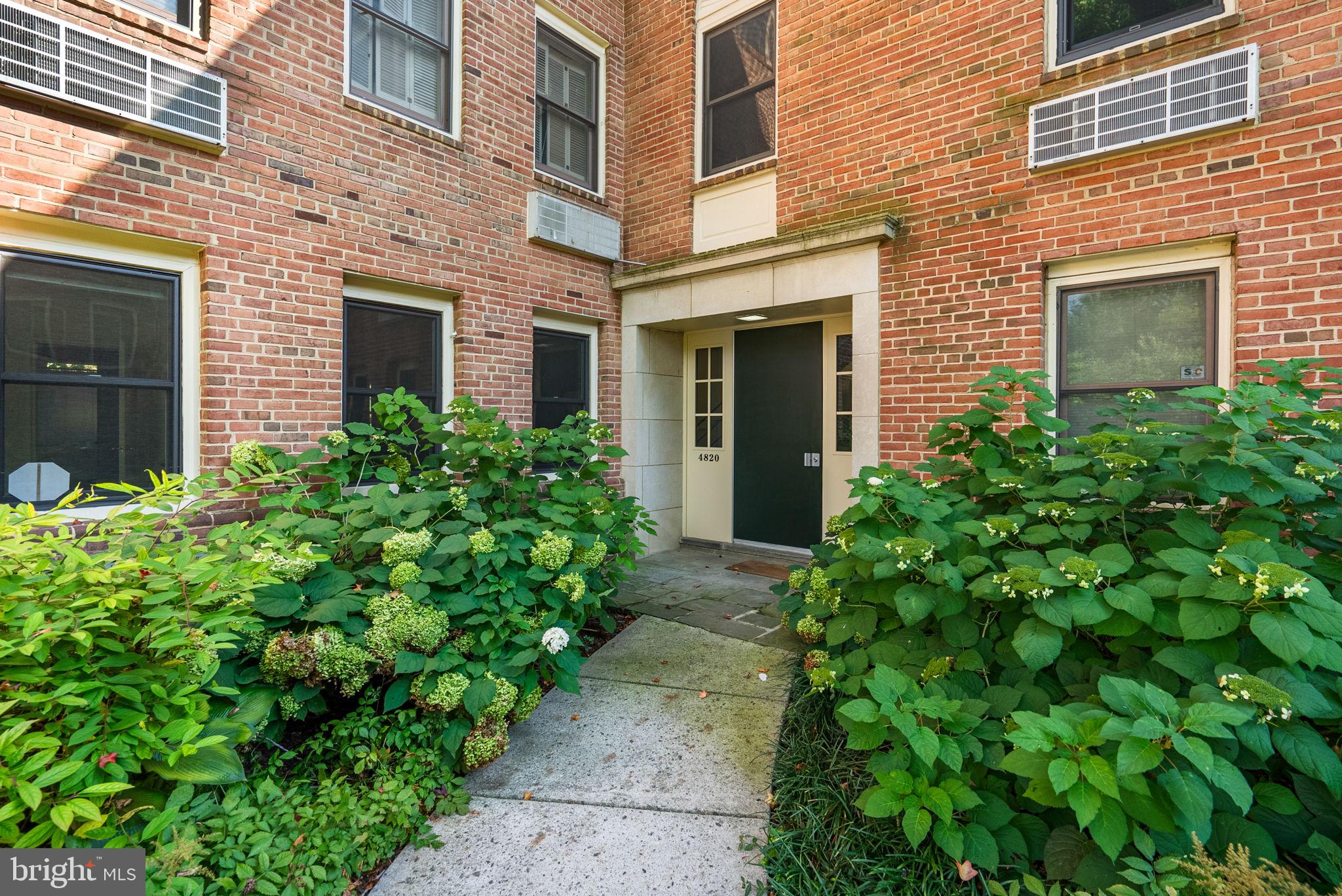 4820 Chevy Chase Drive, Unit 101 Chevy Chase, MD 20815 - Photo 24 of 30 a view of brick house with a yard and plants