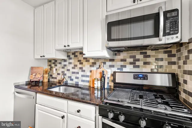 a kitchen with stainless steel appliances granite countertop a stove and a microwave