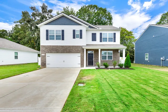 a front view of a house with a yard and garage