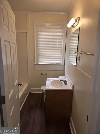 a bathroom with a sink toilet and mirror
