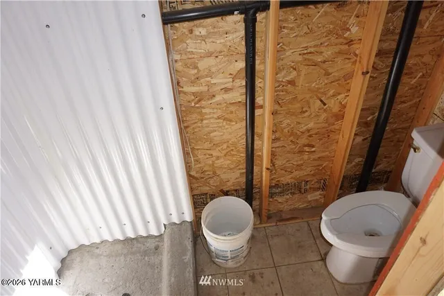 a bathroom with a toilet and a shower curtain