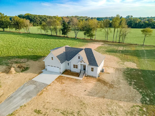 an aerial view of a house with a yard and lake view
