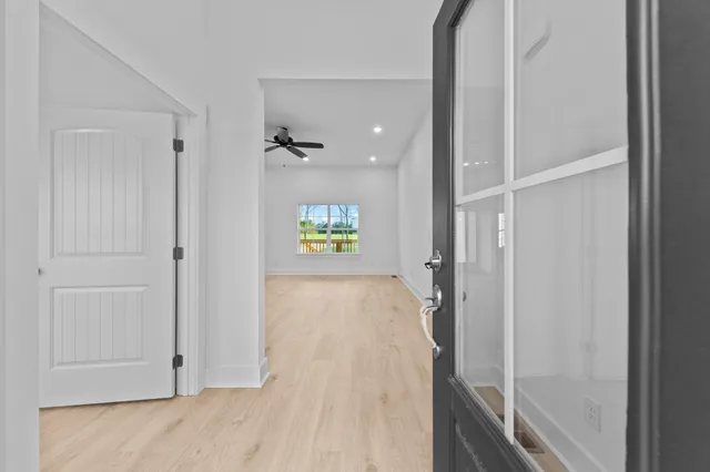 an empty room with windows and ceiling fan