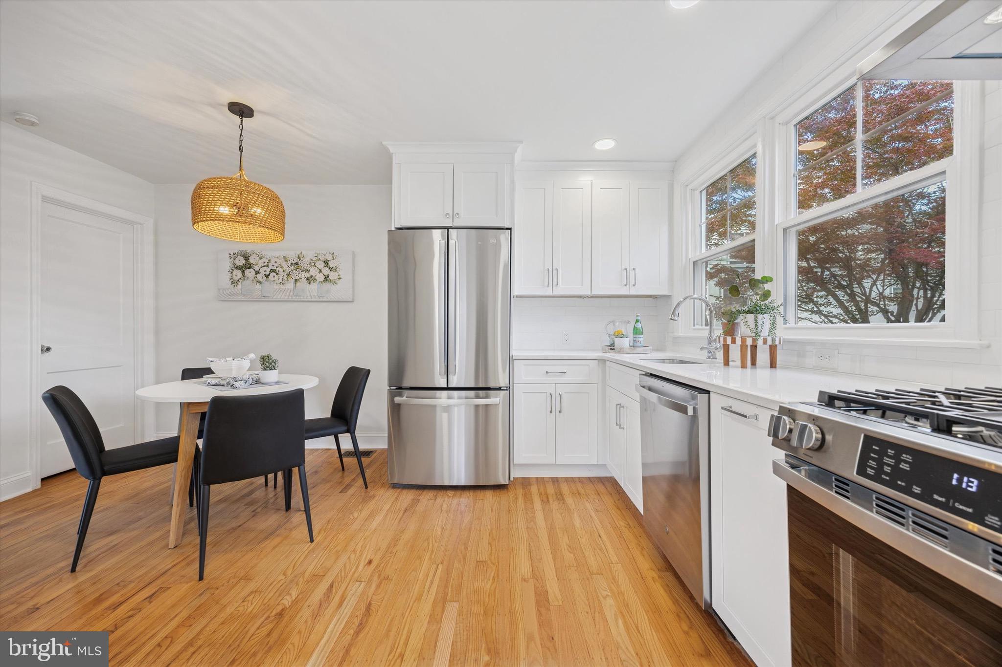 5 Llanfair Road Ardmore, PA 19003 - Photo 9 of 25 a kitchen with a refrigerator a stove a sink and white cabinets with wooden floor