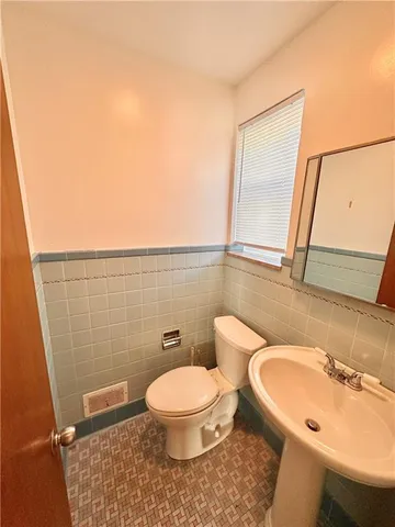 a bathroom with a toilet a sink and mirror