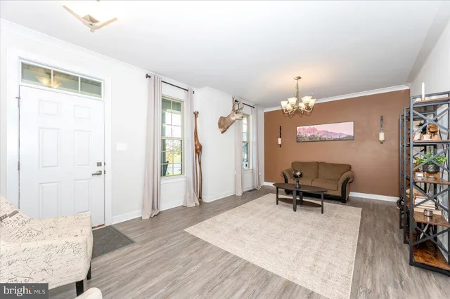 a living room with furniture a chandelier and a dining table