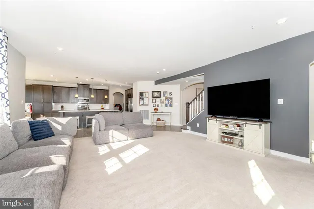 a kitchen with stainless steel appliances granite countertop wooden floors wooden cabinets a sink and a island