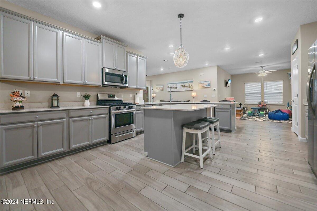 306 Brown Bear Run St. Johns, FL 32259 - Photo 6 of 24 a kitchen with stainless steel appliances kitchen island granite countertop a sink and cabinets