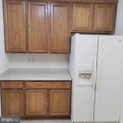 a kitchen with white cabinets and a refrigerator