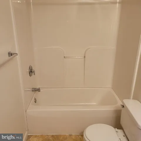 a bathroom with a toilet and a bath tub