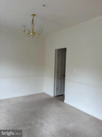 an empty room with a chandelier fan