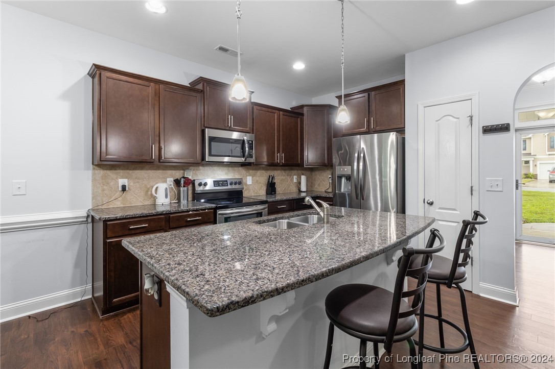 180 Pittfield Run Cameron, NC 28326 - Photo 7 of 33 a kitchen with stainless steel appliances granite countertop a stove a sink a microwave a refrigerator and chairs