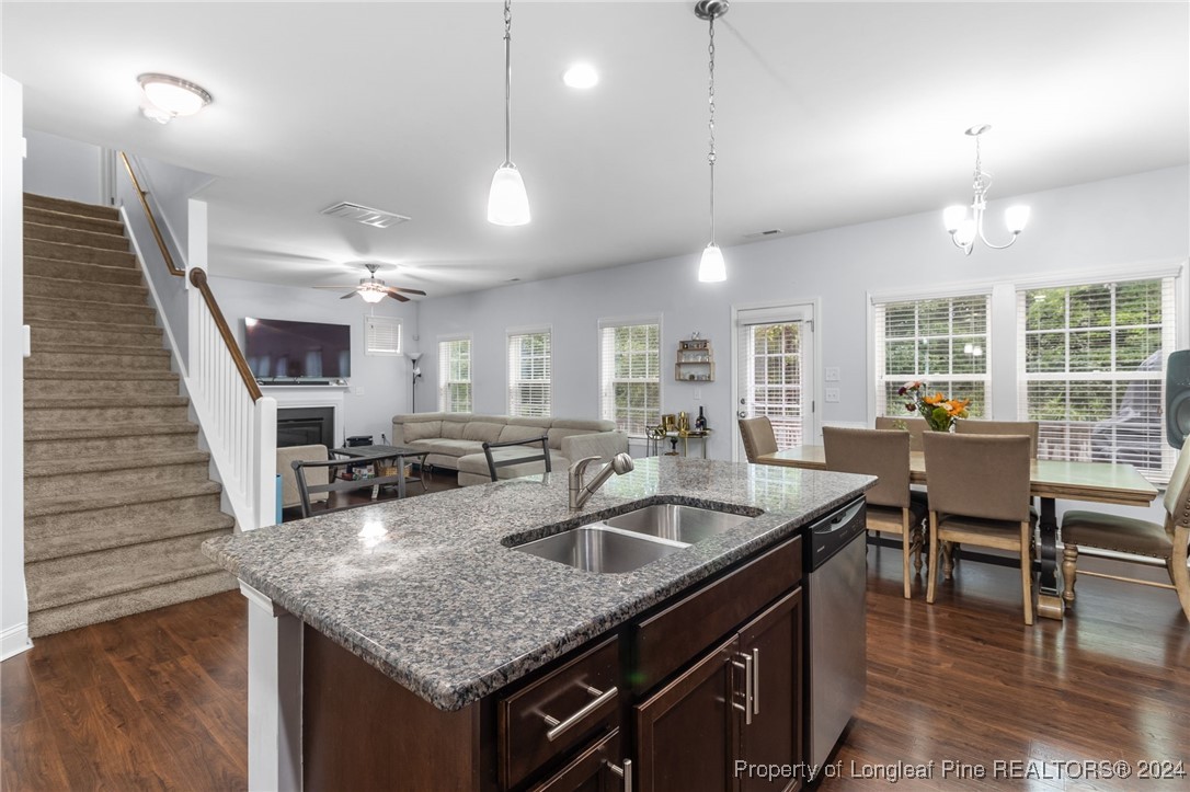 180 Pittfield Run Cameron, NC 28326 - Photo 9 of 33 a kitchen with a stove a kitchen island a dining table and chairs with wooden floor