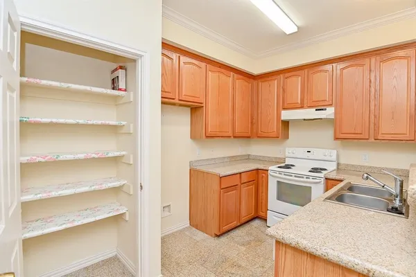 a kitchen with a sink dishwasher stove and cabinets