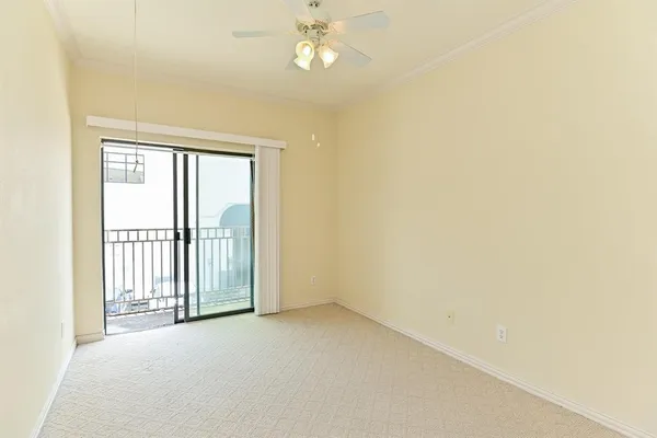 an empty room with a ceiling fan and a window
