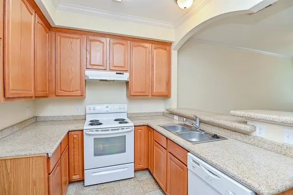 a kitchen with granite countertop a sink stainless steel appliances and cabinets