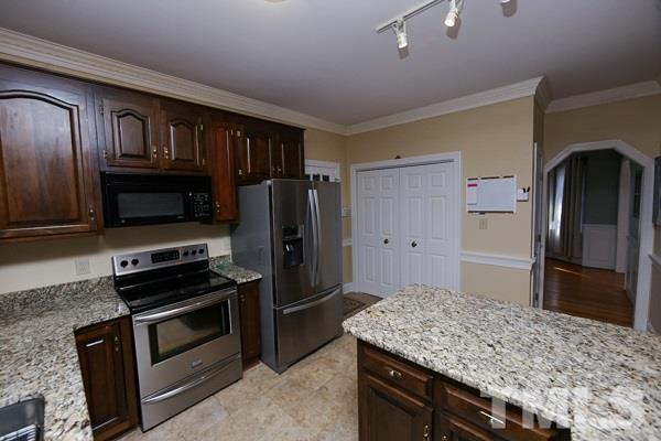 7108 Kinross Drive Raleigh, NC 27613 - Photo 11 of 25 a kitchen with kitchen island stainless steel appliances a refrigerator stove and microwave