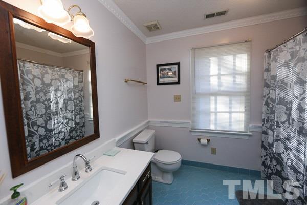 7108 Kinross Drive Raleigh, NC 27613 - Photo 20 of 25 a bathroom with a sink mirror and toilet