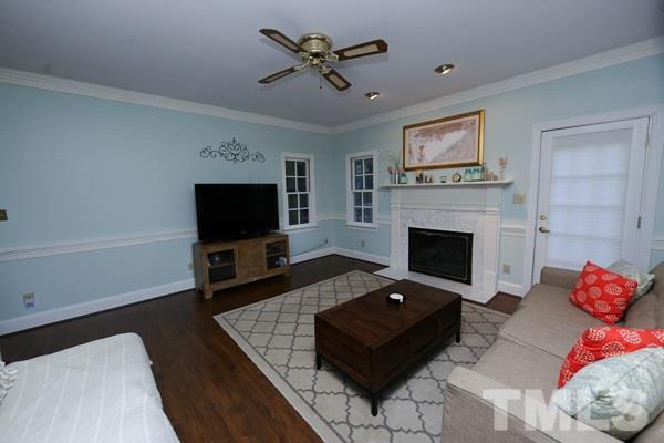 7108 Kinross Drive Raleigh, NC 27613 - Photo 7 of 25 a living room with furniture a flat screen tv and a fireplace