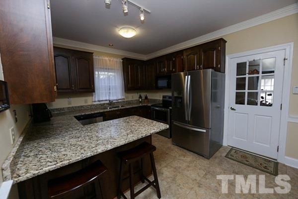7108 Kinross Drive Raleigh, NC 27613 - Photo 9 of 25 a kitchen with stainless steel appliances granite countertop refrigerator sink and cabinets