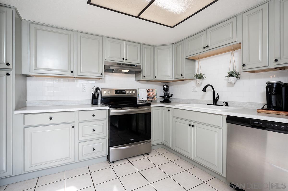 a kitchen with cabinets stainless steel appliances and sink