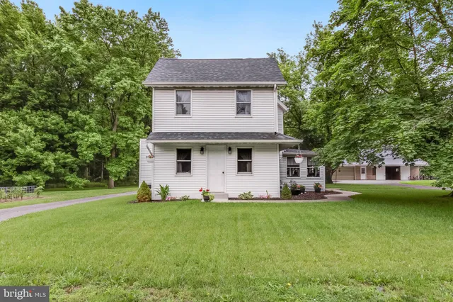 a front view of a house with a yard and trees