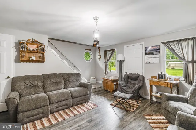 a living room with furniture a window and a chandelier