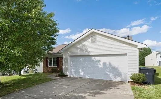 a front view of a house with a garden and garage